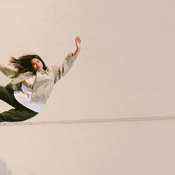 Person in a balanced pose against a serene background.