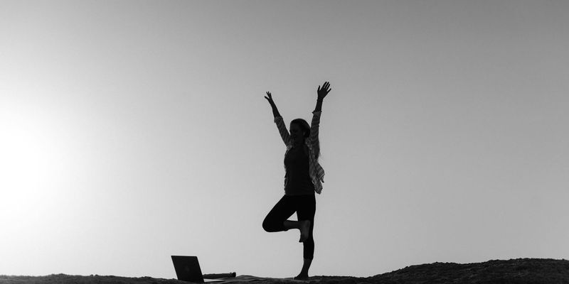 Silhouette of a person stretching during sunrise.